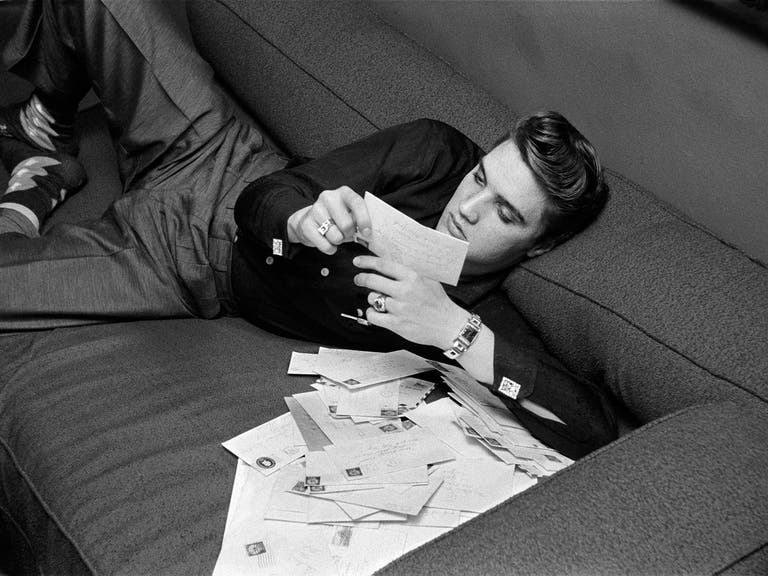 Elvis reads fan letters in his suite at the Warwick Hotel in New York City on Mar. 17, 1956