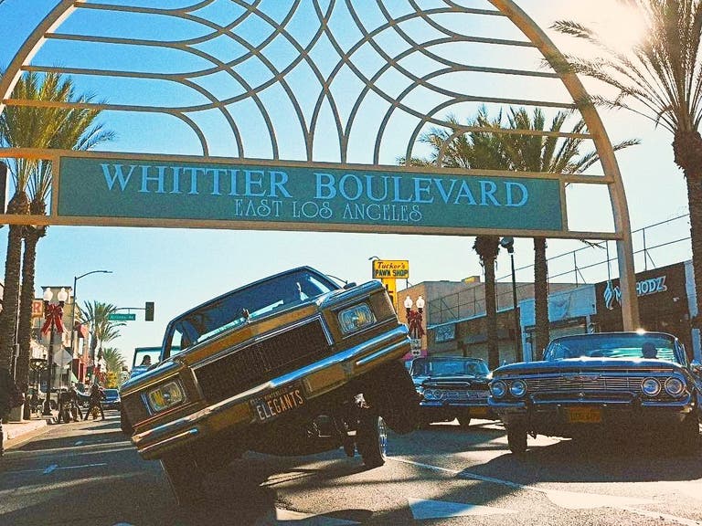 Lowriders in front of the Whittier Boulevard Sign